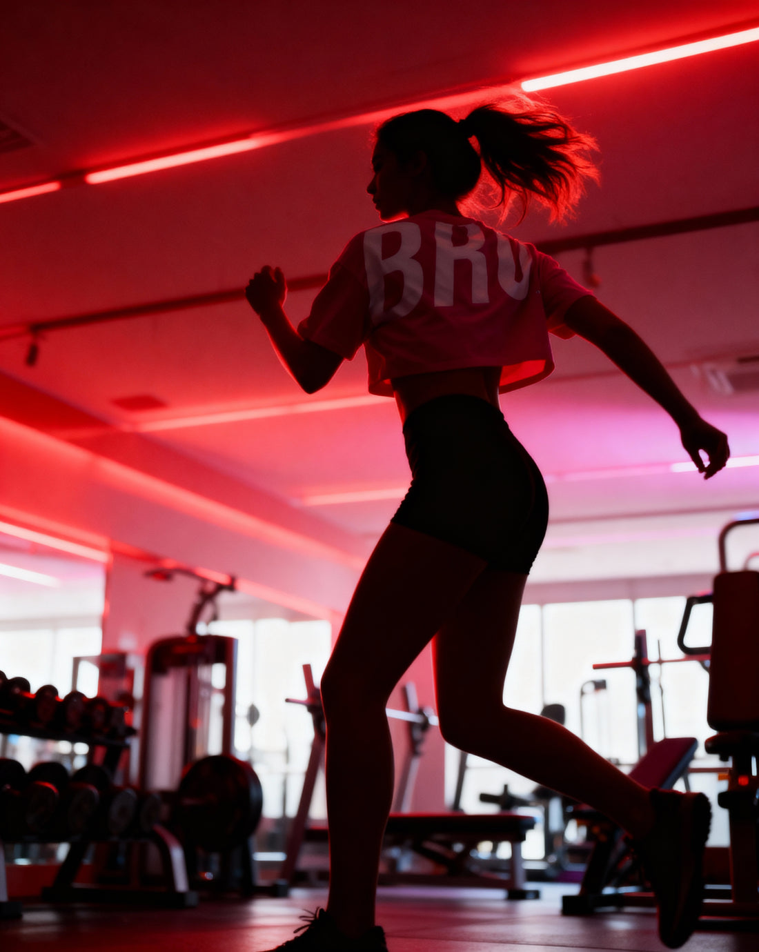 Athlète femme en crop top dos nu BRO dans une salle de sport