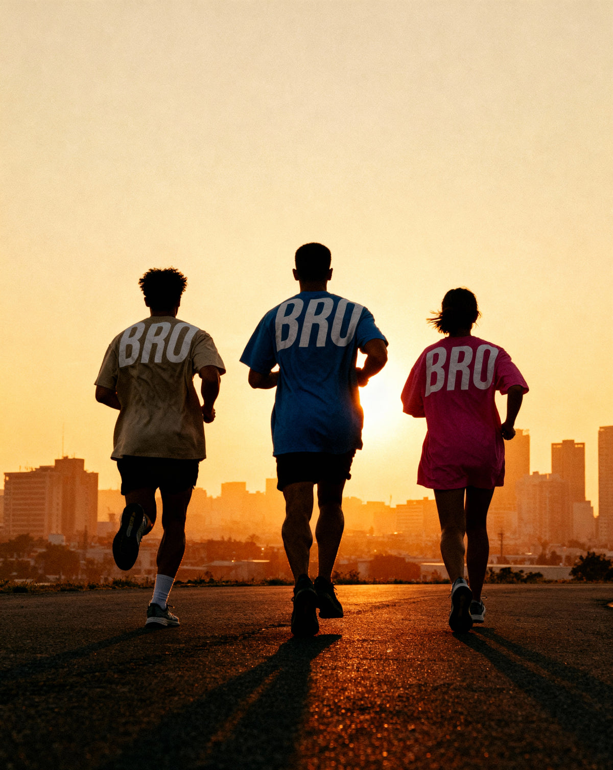 Trois athlètes qui courent ensemble au lever du soleil en tenue de sport BRO Apparel