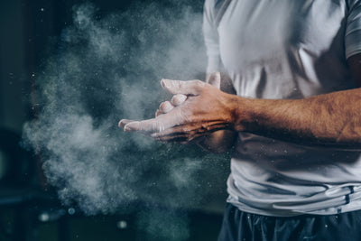 Athlète qui se met de la magnésie sur les mains avant un entraînement CrossFit